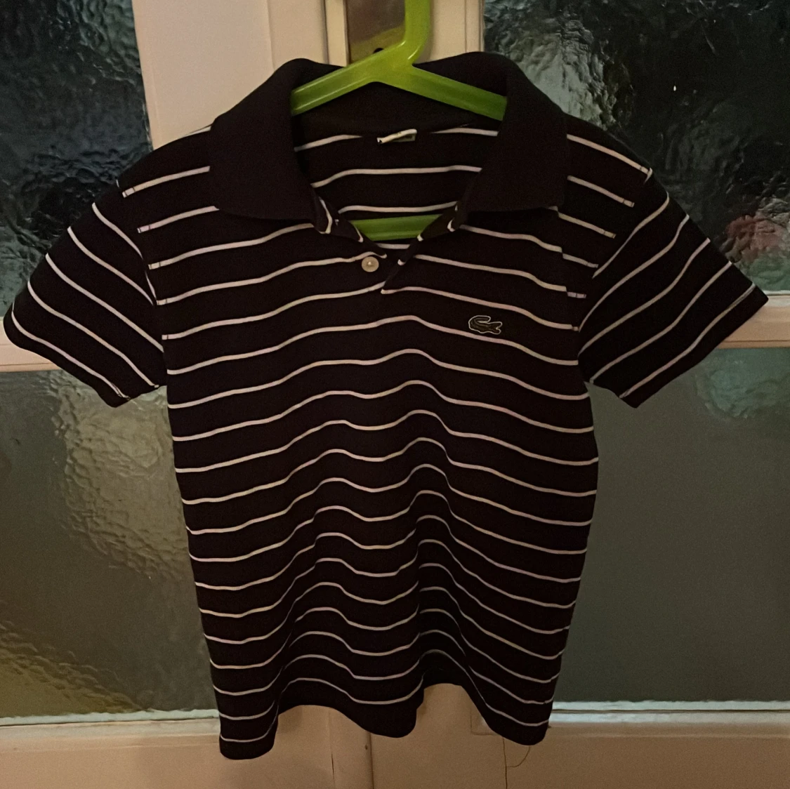 Svart och vit randig pikétröja från Lacoste