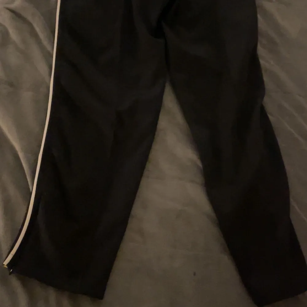 Snygga svarta byxor från Axel Arigato med Aden&Asme på. Perfekta för en stilren och modern look. De här byxorna finns endast 10 stycken i Sverige så passa på nu.. Farkut & Housut.