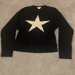 Svart tröja med stjärna GinaTricot  - Säljer en svart tröja med en stor vit stjärna på framsidan. Tröjan är i nytt skick och jag har aldrig haft chansen att ha på mig den.