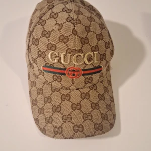 Beige keps från Gucci - Keps från Gucci. Säljer på grund av att jag aldrig använder den, jätte bra skick. Priset kan diskuteras. Original pris: ca 5000kr men säljer för 900 och har inte lådan utan bara käpsen