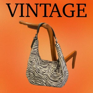 Zebramönstrad hobo-väska - Säljer en supercool zebramönstrad hobo-väska i vintage-stil. Den har ett svart och vitt mönster som verkligen sticker ut. Perfekt för att ge din outfit en unik touch! Väskan har en bekväm axelrem och är rymlig nog för alla dina nödvändigheter. Har även ett medföljande längre band💕💕