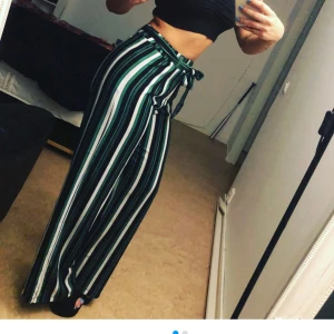 Randiga byxor från Gina Tricot - Säljer ett par supercoola randiga byxor från Gina Tricot i storlek XS men dom är super stretchiga i midjan så man kan även ha dom om man bär strl Medium. De är högmidjade och har en snygg knytning i midjan och är vida.