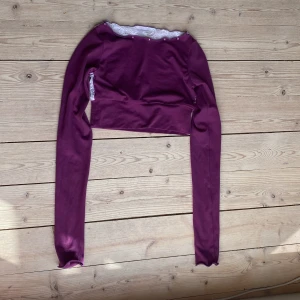 Mörklila träningsmagtröja från karisma - Använt en gång, väldigt bra skick, vit spets på ryggen
