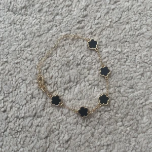 Guld armband med svarta blommor - Hittade denna armbanden i mammas smyckelåda och inte säker på värdet men den såg fet ut så kontakta mig vid frågor
