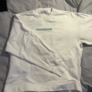 Stone Island sweatshirt - Säljer en fin stone island crewneck sweatshirt i färgen Vit, storlek L,  Den är köpt på nk, kvitto medföljer.