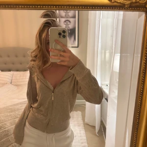 Beige kofta med dragkedja  - Säljer en mysig beige stickad kofta med guld dragkedja framtill. Perfekt för en avslappnad stil och enkel att matcha med andra plagg. Den har långa ärmar och en bekväm passform. Liknar soft goat