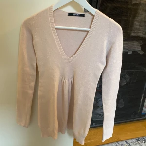 Ljusrosa babydoll tröja - Säljer en ljusrosa babydoll tröja från Nadine med v-ringning och långa ärmar. Tröjan har en elegant och enkel design, perfekt för en stilren look. Tillverkad i Italien. Står ingen storlek men tippar på S / XS men stretchiga material.