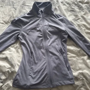 Ljusgrå jacka från H&M Move - Säljer en ljusgrå jacka från H&M Move i storlek S. Jackan har en dragkedja framtill och är långärmad med en hög krage. Storleken stämmer, den är som ny och senast den kom till användning va typ 1 år sedan