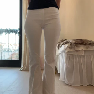 Vita bootcut jeans - Snygga vita bootcut byxor med hög midja. Perfekta för en stilren look. De har en tight passform upptill och blir vidare nedtill, vilket ger en klassisk siluett. Jätte mjuka och sköna. Dom har en stretchig passform