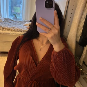 En ribbad brun/orange blus  - En ribbad brun/orange blus med en super fin snörning in mot mitten. Aldrig använt tyvärr 