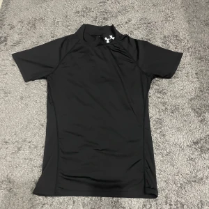 Compressed t-shirt Under Armour - Säljer en svart compressed tränings t-shirt från Under Armour i syntetmaterial. Perfekt för att se snygg ut när du tränar. Skön och funktionell design för aktiva dagar. Vid minsta fundering kontakta oss✔️