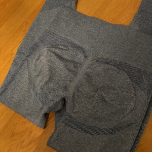 Blå träningsset med leggings och topp - Snyggt blått träningsset med seamless design. Leggingsen har hög midja och tight passform, perfekt för gymmet eller yoga. Matchande topp med. Materialet är stretchigt och andas bra.