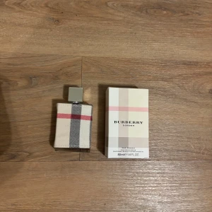 Burberry London Parfym - Säljer en elegant Burberry London parfym i en 50 ml flaska. Flaskan är klädd i det ikoniska Burberry-mönstret med rutor i beige, svart och rött. Den stilrena designen gör den till en perfekt accessoar för alla tillfällen. Perfekt present till din flickvän. Den är helt full