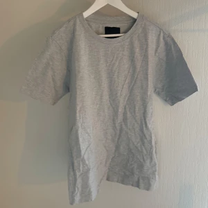 T-shirt  - Säljer en klassisk grå t-shirt från 157 i storlek M. Den har en enkel design med rund hals och korta ärmar, perfekt för en avslappnad stil. Passar bra till jeans eller shorts för en casual look.