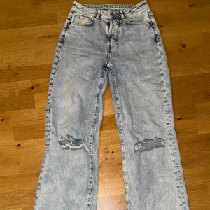 Blå straight jeans med slitningar - Blå straight jeans från Bik Bok med slitningar på knäna. 