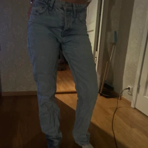 Ljusblå jeans - Snygga ljusblå jeans med medelhög midja och en straight passform. Perfekta för en avslappnad stil. De har en klassisk design med fem fickor och knappgylf.