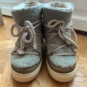 Grå boots från Inuikii - Säljer ett par snygga grå boots från Inuikii med mjukt foder och snörning. Skorna har en robust sula och är perfekta för kyligare väder. De har en unik design med en kombination av mocka och syntetmaterial. Skorna är i storlek 39 men är liten i storleken så skulle säga att de är i storlek 38. Skriv för frågor.
