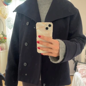 Kort kappa - Trendig kappa från Gina i jättebra skick. Skriv för fler bilder. Kappan är ren ursäkta min smutsiga spegel.