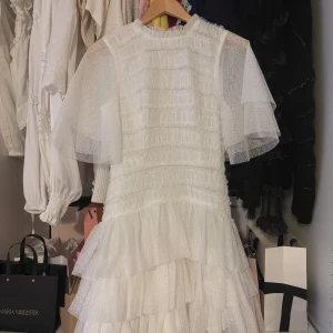 Vit klänning från By Malina - Säljer en superfin vit spetsklänning från By Malina. Klänningen har korta ärmar och en volangdetalj vid halsen. Perfekt för sommarens alla tillfällen! 💫Helt ny köptes för 3800 säljer för 1900! 