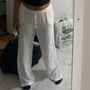 Vita linnebyxor - Säljer ett par vita linnebyxor med loose passform. Byxorna har en högmidjad design och är perfekta för en avslappnad stil. De är enkla och stilrena, vilket gör dem lätta att matcha med olika toppar.