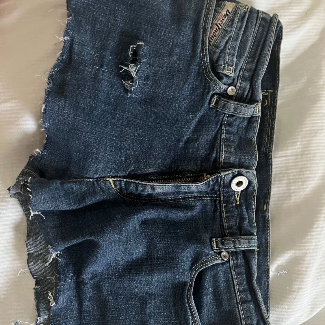 Blå jeansshorts med slitningar