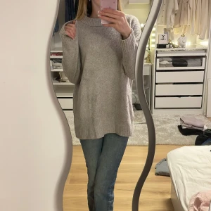 Grå stickad tröja  - Mysig grå stickad tröja, perfekt för kyliga dagar.  Ganska lång i modellen