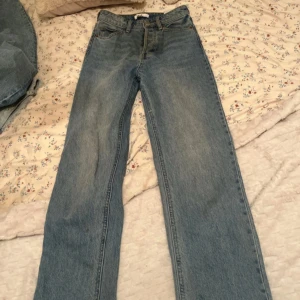 Blå jeans från H&M - Snygga blå jeans från H&M med klassisk design. De har en rak passform och är högmidjade, vilket ger en tidlös look. Perfekta för en avslappnad stil.