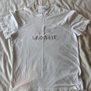 Vit t-shirt från Lacoste - Vit t-shirt från Lacoste! Jätteskön, asbra kvalitet. skick 9/10. storlek US L, uppskattar den till eu M