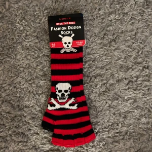 Randiga knästrumpor med dödskallemotiv - Tuffa vantar i onesize. Står fel på etiketten. Det är inte socks. Helt nya.