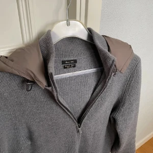 Grå stickad cardigan - Massimo Dutti - Tja! Säljer nu min tvärsnygga cardigan från Massimo Dutti. Tröjan är slutsåld överallt och sjukt eftertraktad!🙌  Skick: 8/10. Har ett litet hål i ena armen men inget som märks av andra och kommer inte att förvärras. Storlek: L, passar S. Optimal längd 180cm Nypriset låg runt 2500kr när den såldes. Kontakta oss för fler bilder och info!🤝 Kolla även vår profil för mycket kläder från Raffe och Morris!🥳