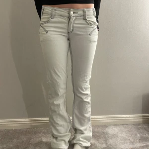 Lågmidjade vit/gråa jeans - Modellen är 165cm. Midjemått: 39 tvärs över. Innerbenslängd: 85. Dem är uppsprättade längst ner. Jeansen är vit grå. Hör av er som om ni har några frågor💗