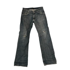 Mörkblå Bastini boot cut jeans - Snygga mörkblå bootcut jeansbyxor med en klassisk straight passform. De har en traditionell femficksdesign och en diskret slitning på framsidan för en trendig look. Perfekta för en avslappnad stil. Passar perfekt för dig som är runt  180.