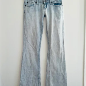 Väldigt låg midja bootcut jeans - Har bild på alla mått så fråga gärna. Färgen är lite svår att få bild på men de första bilderna visar färgen ganska bra. (På vissa bilder ser färgen annorlunda ut och får det se ut som att det fläckar som egentligen ej finns). Finns snöre i byxorna så de går att tighta till, går att ta ut också. Finns ingen riktig storlek men skulle säga xs/xxs/xxxs. Passar ej mig som har S, så har tyvärr ej bilder med de på. Ej mycket strech. Inga skador förutom små svarta prickar (3) syns ej när på. Fråga gärn