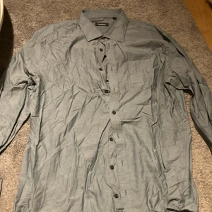 Ljus grön skjorta från Dressmann - Säljer en stilren ljus grön skjorta från Dressmann i storlek 3XL. Skjortan har långa ärmar och knappar framtill. Perfekt för en klassisk look. Snygg men också färgglad, perfekt till sommaren! Skriv till mig för övriga frågor eller bilder. Pris kan alltid diskuteras.