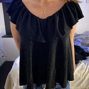 Svart offshoulder topp - Snygg svart offshoulder topp med volangdetaljer. Passar till allt!