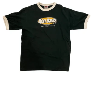 Mörkgrön Ben Davis t-shirt - Säljer en mörkgrön t-shirt från Ben Davis med vit text och logga på framsidan och baksidan. T-shirten har korta ärmar och vita detaljer vid ärmslut och halsringning. Perfekt för en avslappnad stil. Igenkligen storlek M men den passar S.