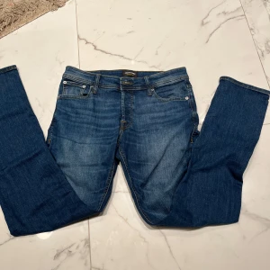 Blå jeans från Jack & Jones - Säljer dessa schyssta jack and jones jeans med slim fit passform och storlek 31 i midjan samt 32 i längd. De är i grymt skick, använda en enstaka gång! Hör av dig vid fundering!!