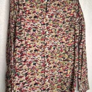 Färgglad skjorta från A.O.CMS - Säljer en färgglad skjorta från A.O.CMS i storlek M. Skjortan har ett unikt mönster i flera färger som röd, grön och svart. Den är långärmad med knappar framtill och en bröstficka. Perfekt för dig som vill sticka ut!