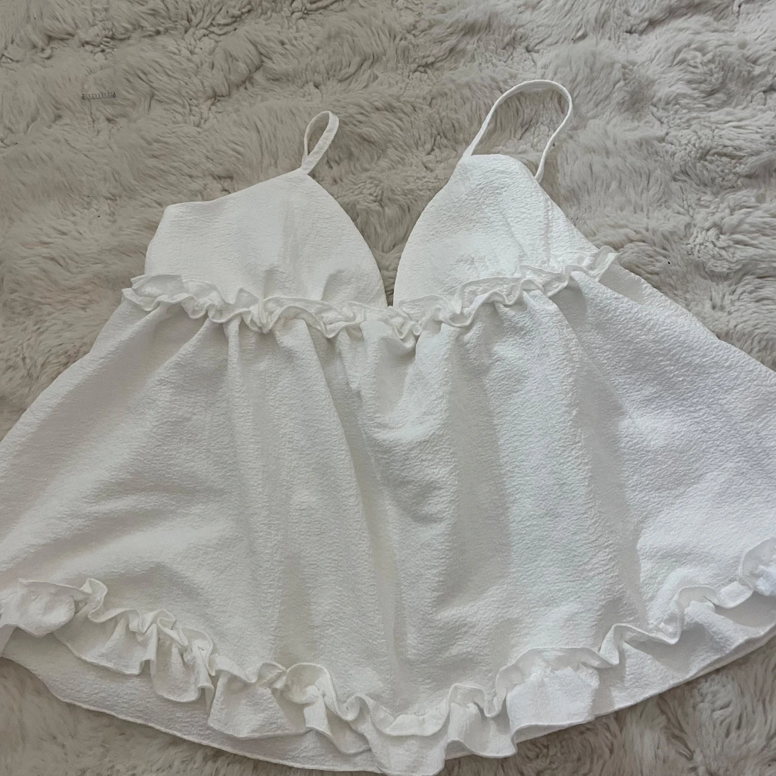 Vit topp med volangdetaljer