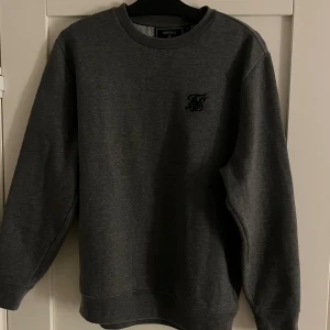Grå sweatshirt  - Säljer denna mörk gråa oanvända sweatshirt från SikSilk. Tröjan är endast testad, anledningen till att jag säljer är pga den var för lite för mig. Nypris på hemsidan är 700kr