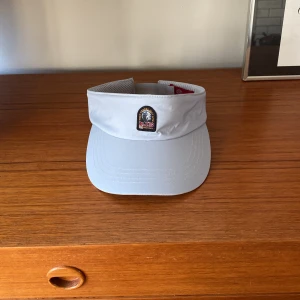 Vit/ silver solskärm från Parajumpers - Säljer min solskärm från parajumper. Har knappast använt den bara några enstaka gånger. Den är äkta!!! 