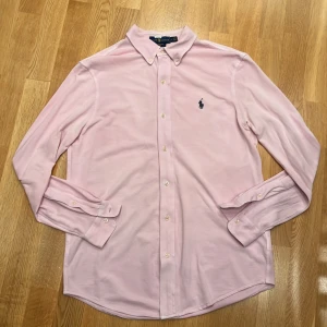 Rosa skjorta från Ralph Lauren - Skitsnygg skjorta från Ralph Lauren i slim/regular fit. Fint skick och inga defekter. Ser lite solblekt ut men det är bara ljuset. 
