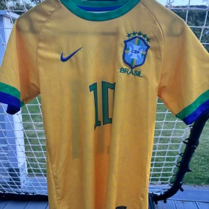 Brasilien tröja - Brasilien tröja, säljer den pga att den blivit för liten och inte passar mig längre. Den är i storlek 176 och där bak står det Neymar jr. 