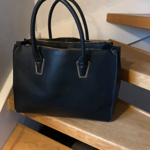 Svart väska från H&M - Bra skick, sällan använd. Stort utrymme med många små fack.
