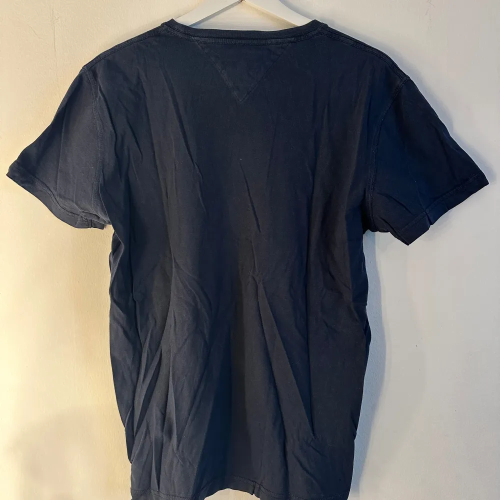 Tommy Hilfiger t-shirt med tryck. Trycket är lite slitet (se bild 2) och sedan har tröjan ett litet litet hål (se bild 3) annars hel och ren. Storlek M. T-shirts.