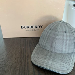 Burberry Keps (ÄKTA) - Detta är min Burberry keps som jag säljer pågrund av att jag enbart inte tar på mig den längre, den är äkta och allt medföljer finns digitalt kvitto inte i pappersform men box o allt kommer med 