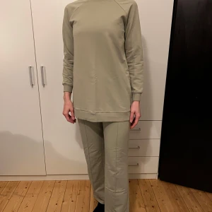 Ljusgrön set - Säljer en stilren och bekväm set. Perfekt för en avslappnad look eller mysiga dagar hemma. Tröjan har en normal passform och är gjord i ett mjukt material som känns skönt mot huden. Byxorna är vida och bekväma 