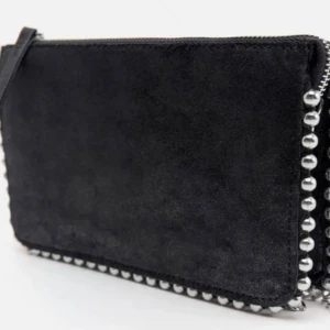 Svart väska från zara  - Snygg svart väska i svart med coola silverfärgade nitar längs kanterna. Perfekt för en utekväll eller fest! Den har en dragkedja upptill för säker förvaring av dina saker. En stilren och edgy accessoar som passar till många outfits.