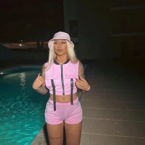 Rosa croppad västtopp med shorts - Snygg rosa croppad västtopp med tillhörande shorts. Perfekt för en trendig look vid poolen eller på stan. Passar S/M.