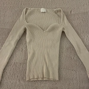 Beige ribbad topp från H&M - Säljer en superfin beige ribbad topp från H&M. Knappt använd, kanske 1-2 gånger